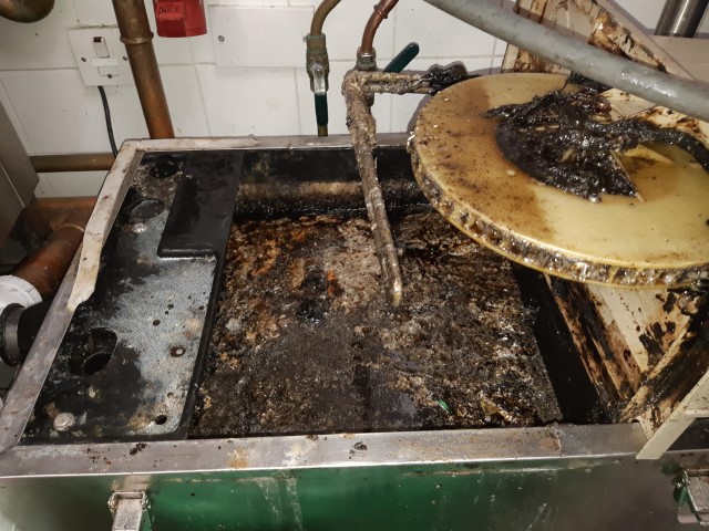 Blocked up grease trap in a kitchen