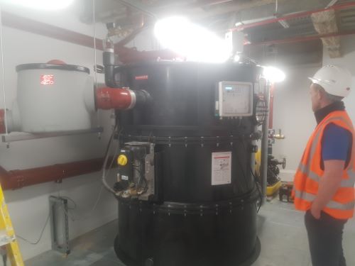 Man with a grease trap doing a repair